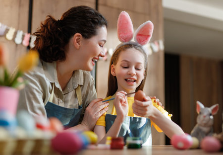 A joyful mother-daughter duo engages in Easter egg painting, embodying familial warmth and...