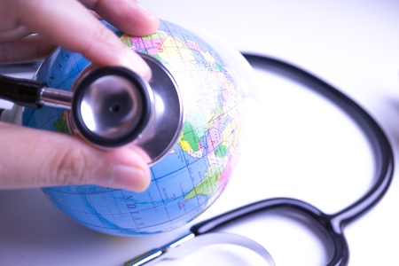 hand with stethoscope auscultating worldの写真素材