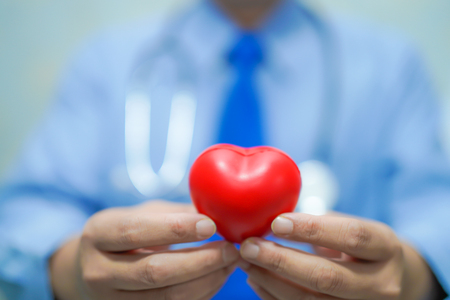 Asian smart man doctor holding a red heart : healthy strong medical concept.の写真素材