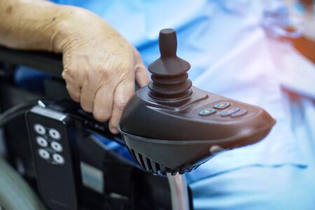 Asian senior or elderly old lady woman patient on electric wheelchair with remote control at nursing...