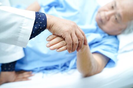 Holding Touching hands Asian senior or elderly old lady woman patient with love, care, helping, encourage and empathy at nursing hospital ward : healthy strong medical conceptの写真素材