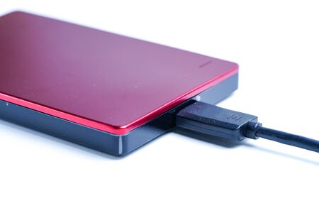 Red external hard disk isolated on white background.の写真素材