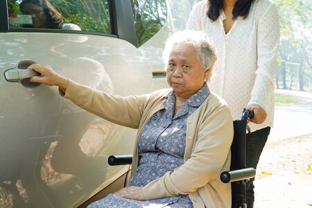 Asian senior or elderly old lady woman patient sitting on wheelchair prepare get to her car : healthy strong medical concept.の写真素材