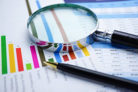 Magnifying glass on charts graphs spreadsheet paper. Financial development, Banking Account,...
