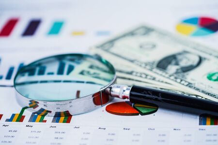 Magnifying glass on charts graphs spreadsheet paper. Financial development, Banking Account,...