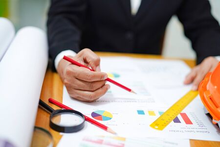 Architect or engineer working project accounting with graph with tools in office, Construction...