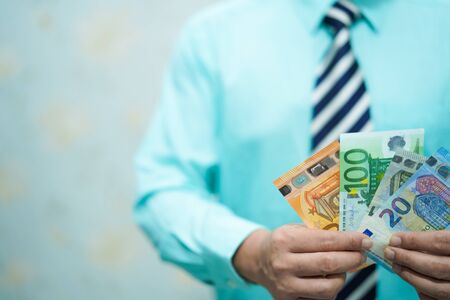 Young business smart manager holding EU banknotes money working with new success startup project, Banking, Account, Investment Analytic research data economy, trading company concept.の写真素材