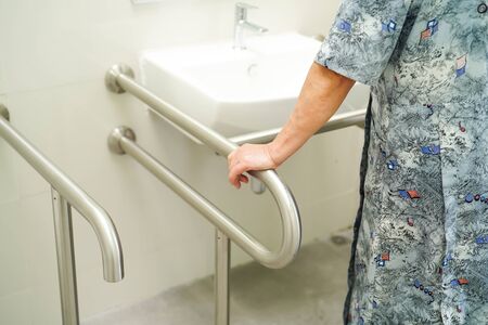Asian senior or elderly old lady woman patient use toilet bathroom handle security in nursing hospital ward, healthy strong medical concept.の写真素材