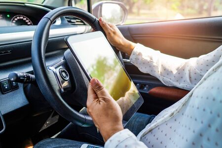 Holding tablet in car to communication with family and friends.の写真素材