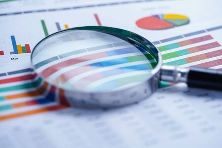 Magnifying glass on charts graphs spreadsheet paper. Financial development, Banking Account,...