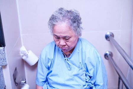Asian senior elderly old lady woman patient in toilet bathroom at nursing hospital ward : healthy strong medical concept.の写真素材