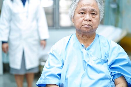 Asian senior or elderly old lady woman patient smile bright face while sitting on bed in nursing hospital ward : healthy strong medical conceptの写真素材