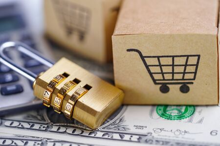 Golden security digital password lock key and Box with shopping cart logo on us dollar banknotes : Import Export online or eCommerce delivery service store product shipping, trade, supplier concept.の写真素材