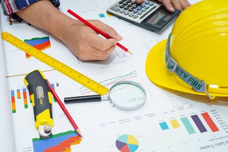 Architect or engineer working project accounting with graph with tools in office, Construction...