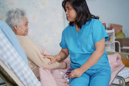 Asian nurse physiotherapist doctor care, help and support senior or elderly old lady woman patient at hospital ward : healthy strong medical concept.の写真素材