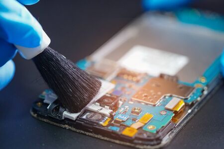 Asian Technician repair and cleaning dirty micro circuit main board of smartphone electronic technology with brush : hardware, mobile phone, smartphone, upgrade concept.
の写真素材
