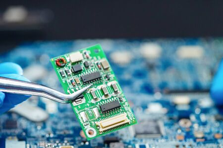 E-waste, technician repairing inside of hard disk by soldering iron. Integrated Circuit. the concept...