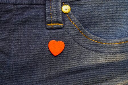 Red heart on close up at front of woman jean.