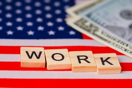 WORK alphabet on USA America flag with dollar banknotesの写真素材