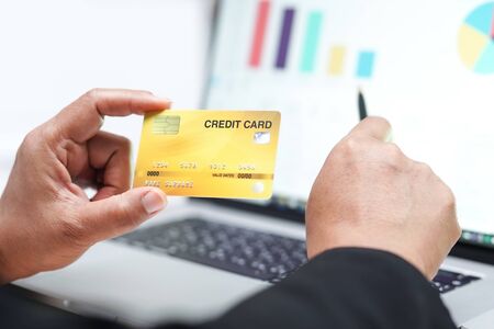 Asian accountant holding credit card and working, calculate, analyzing report project accounting...