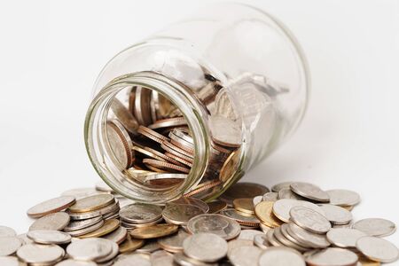 Coins in glass bottle on white background