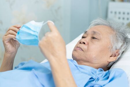 Asian senior or elderly old lady woman patient wearing a face mask in hospital for protect infection and kill Novel Coronavirus (2019-nCoV) Covid-19 virus.の写真素材