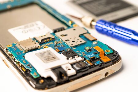 Mainboard circuit inside of mobile phone with soldering iron, Technology concept.