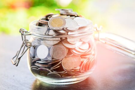 Save money coins in grass jar : Business finance investment concept.