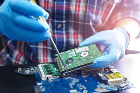 Asian Technician repairing micro circuit main board computer electronic technology : hardware,...