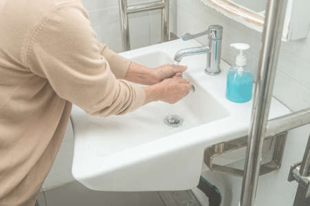 Asian washing hand by liquid soap and clean water for protect safety infection and kill Novel Coronavirus Covid-19 virus, bacteria and germs.の写真素材