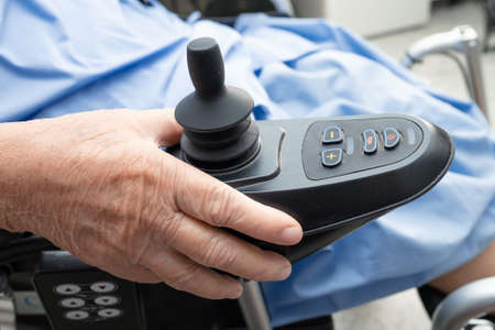 Asian senior or elderly old lady woman patient on electric wheelchair with remote control at nursing...