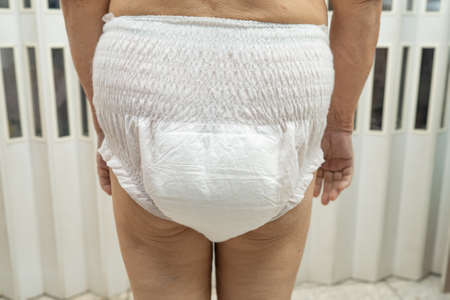 Asian senior or elderly old lady woman patient wearing incontinence diaper in nursing hospital ward,...