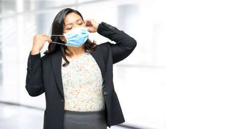 Asian lady wearing mask new normal in office for protect safety infection Covid-19 Coronavirus with...