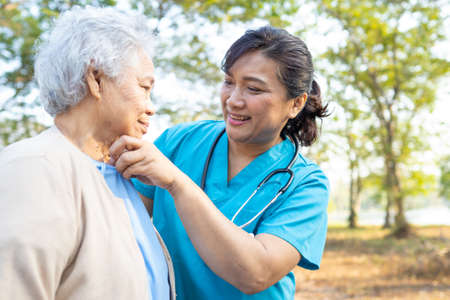 Doctor help and care Asian senior or elderly old lady woman walking at park in happy fresh holiday.の写真素材
