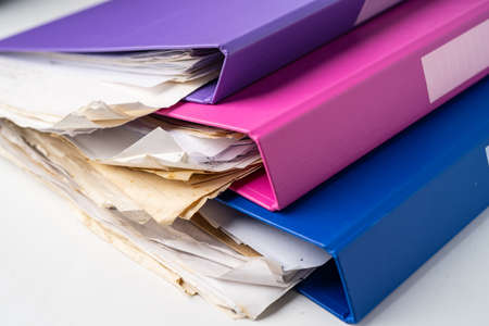 File Folder Binder stack of multi color on table in office.