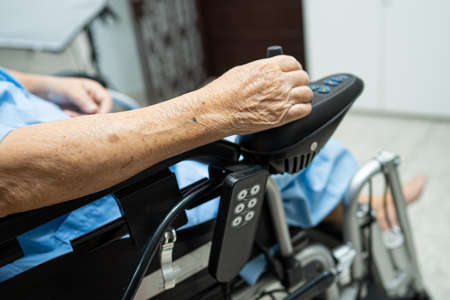 Asian senior or elderly old lady woman patient on electric wheelchair with remote control at nursing hospital ward, healthy strong medical conceptの写真素材