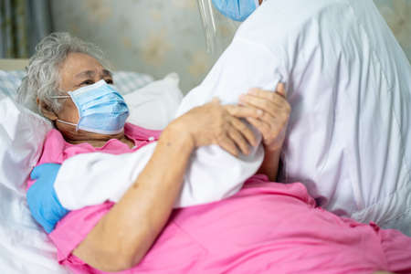 Doctor help and check Asian senior or elderly old lady woman patient wearing a face mask in hospital for protect infection Covid-19 Coronavirus.の写真素材