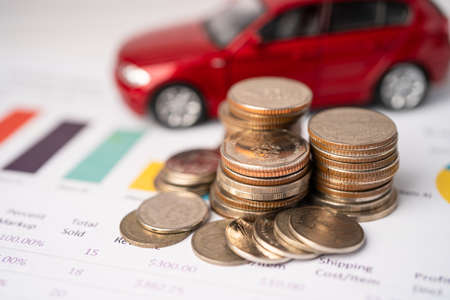 Car with coins on graph background, Car loan, Finance, saving money, insurance and leasing time concepts.の写真素材