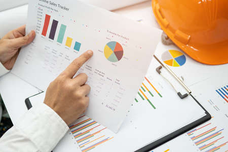 Asian accountant working and analyzing financial reports project accounting with chart graph and...