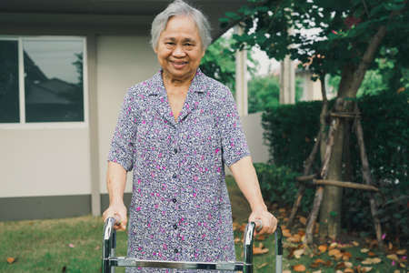 Asian senior or elderly old lady woman patient walk with walker in park at home, healthy strong...