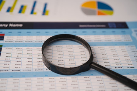 Magnifying glass on spreadsheet charts graphs paper. Financial development, Banking Account,...