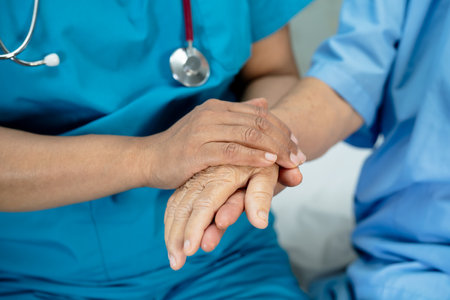 Doctor holding hands Asian senior or elderly old lady woman patient with love, care, encourage and empathy at nursing hospital ward, healthy strong medical conceptの写真素材