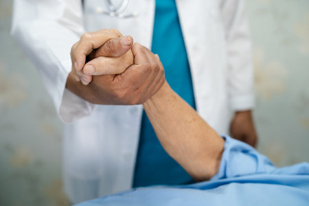 Holding hands Asian senior or elderly old lady woman patient with love, care, encourage and empathy at nursing hospital ward, healthy strong medical conceptの写真素材