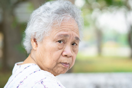 Asian senior or elderly old lady woman sitting in park, healthy strong medical concept.の写真素材