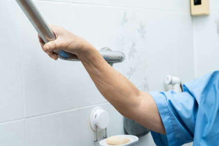Asian senior or elderly old lady woman patient use toilet bathroom handle security in nursing hospital ward, healthy strong medical concept.の写真素材