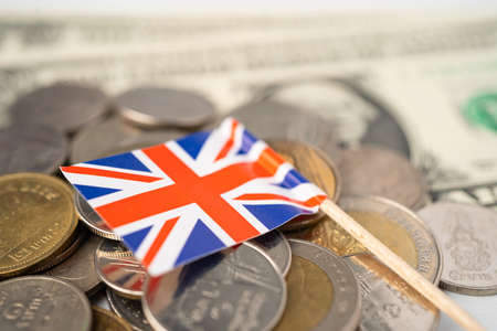 Stack of coins with United Kingdom flag on white background.