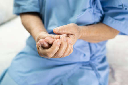 Asian senior or elderly old lady woman patient feel pain at arm and hand on bed in nursing hospital ward, healthy strong medical concept.の写真素材
