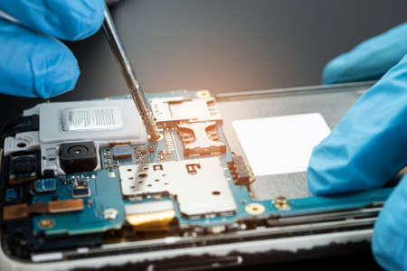 technician repairing inside of hard disk by soldering iron. Integrated Circuit. the concept of data, hardware, technician and technology.の写真素材
