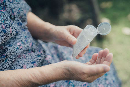 Asian senior or elderly old lady woman patient washing hand with alcohol sanitizer gel to protect safety infection and kill , bacteria and germs.の写真素材