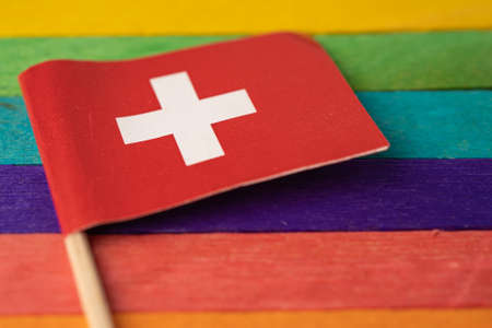 Switzerland flag on rainbow background symbol of LGBT gay pride month  social movement rainbow flag is a symbol of lesbian, gay, bisexual, transgender, human rights, tolerance and peace.の写真素材